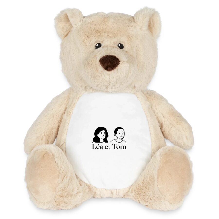Peluche ourson personnalisée, coloris blanc marron moyen, posée sur un panier